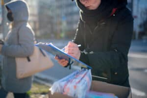 A person filling out information outside. This image is being used for PolicyWise's story 
