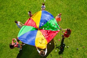 Children playing with a parachute. The image is to represent teamwork